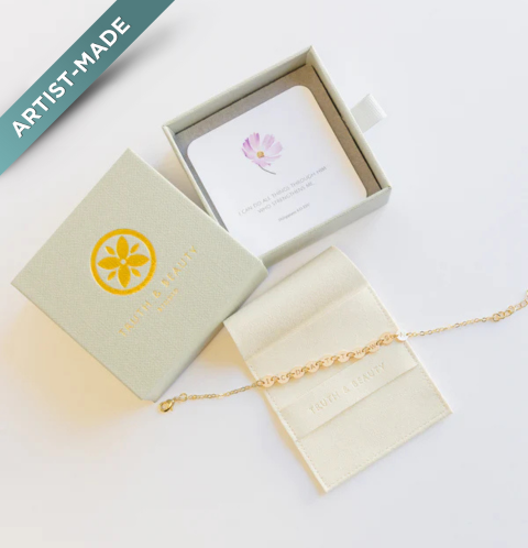 A gold fill bracelet with a lobster clasp closure, displayed alongside its packaging which includes a card and a gift box with the Living Word Jewelry™ logo.