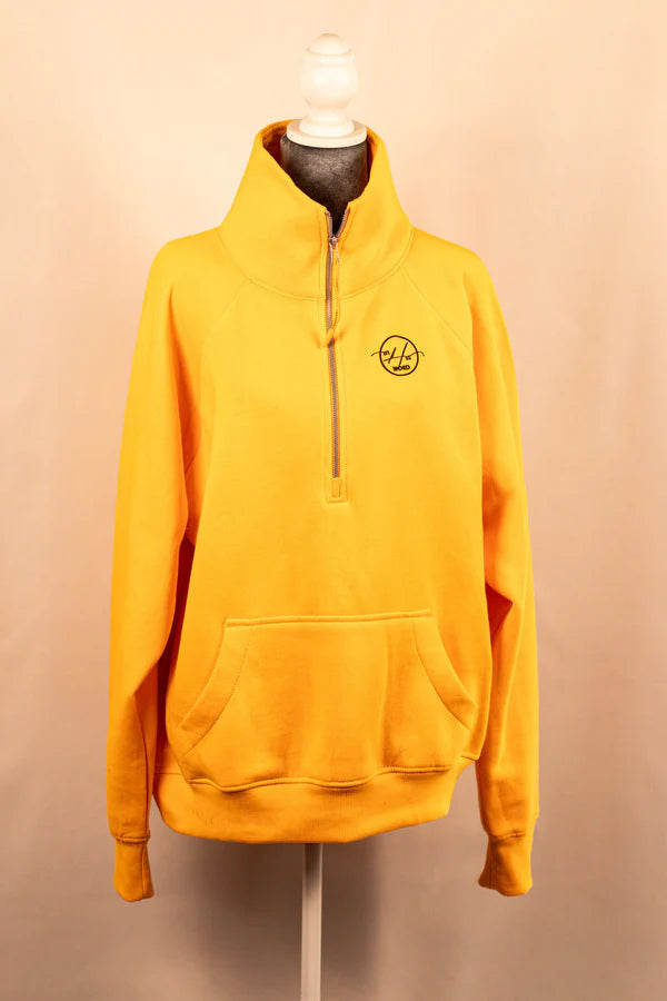 A yellow 3/4 zip sweatshirt displayed on a mannequin, with a logo on the upper left chest area.