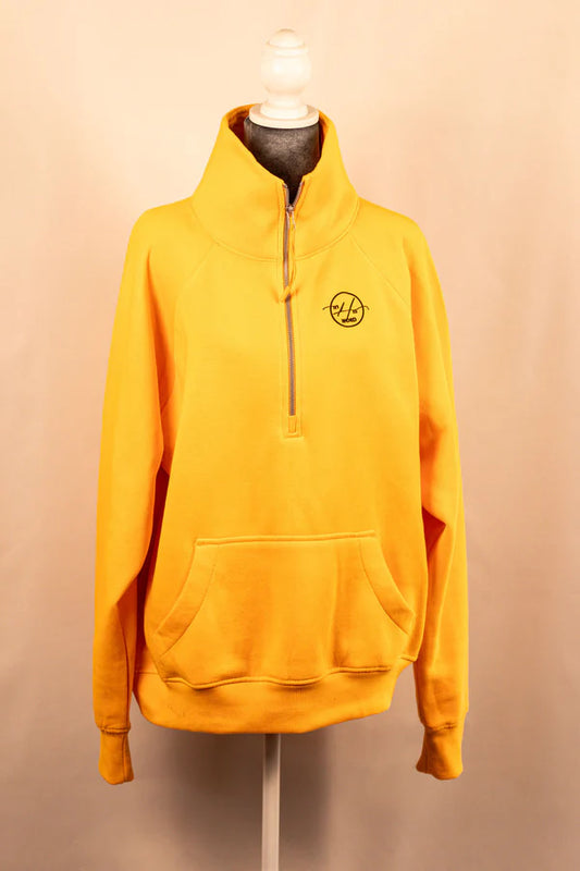 A yellow 3/4 zip sweatshirt displayed on a mannequin, with a logo on the upper left chest area.