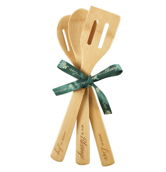Set of wooden utensils with a green ribbon on a white background