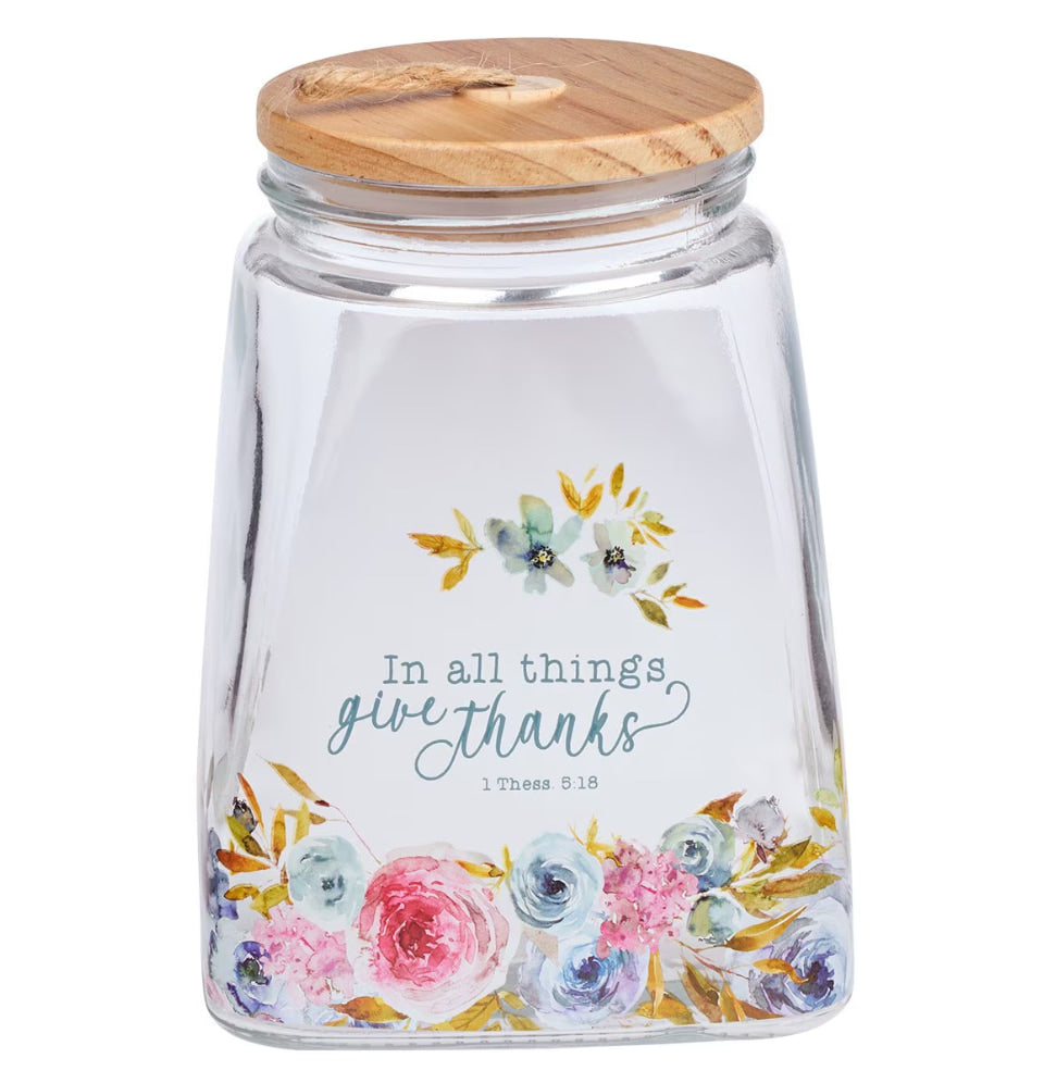 Glass jar with floral design and wooden lid on a white background