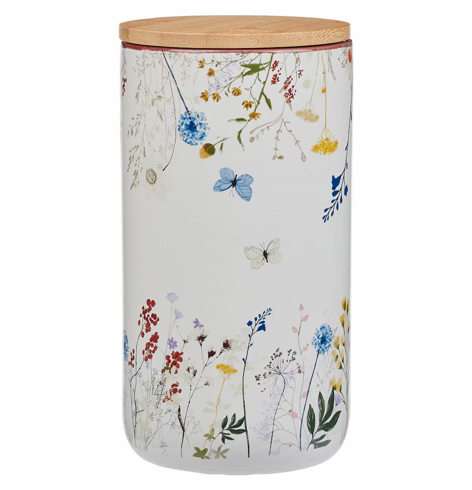 Decorative storage jar with floral design and wooden lid on a white background