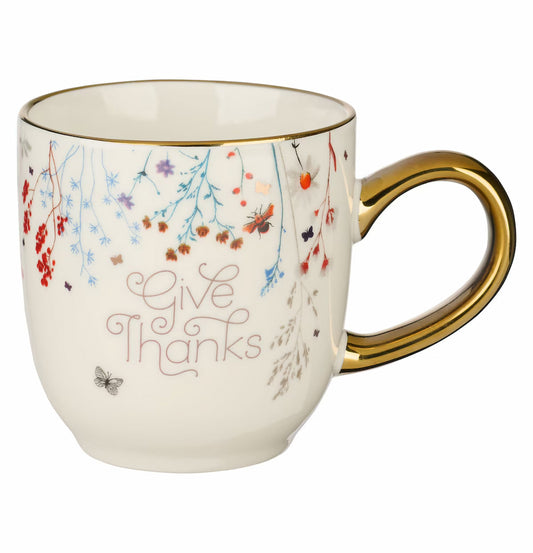Mug with 'Give Thanks' text and floral designs on a white background