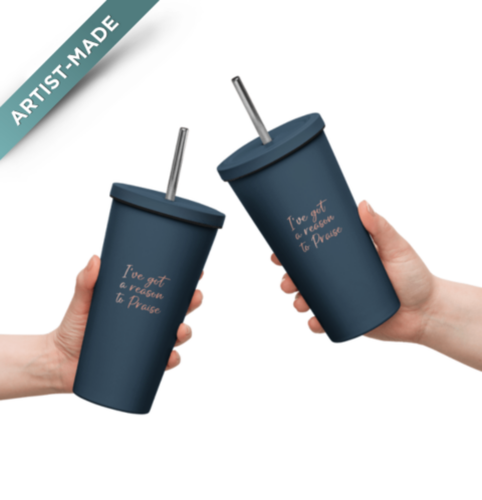 Two hands holding navy blue insulated tumblers with straws, each displaying a unique phrase on the side.