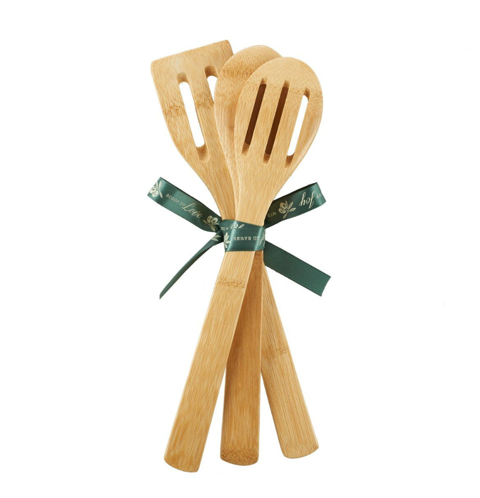 Set of wooden kitchen utensils tied with a green ribbon on a white background