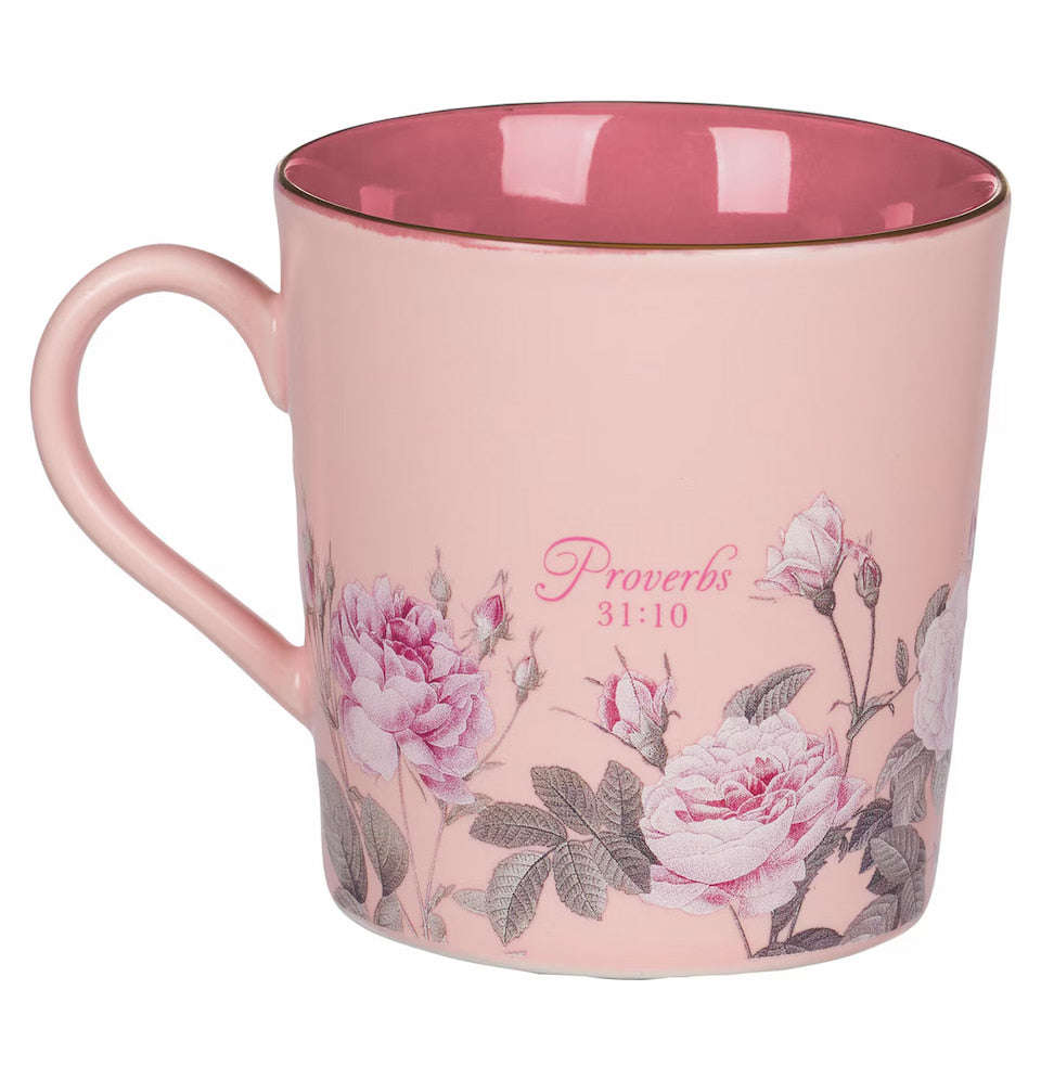 Pink mug with floral design and 'Proverbs 31:10' text on a white background