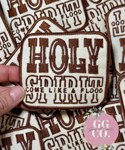 Embroidered patch with text held over a patterned background, featuring the brand 'GG CO'.