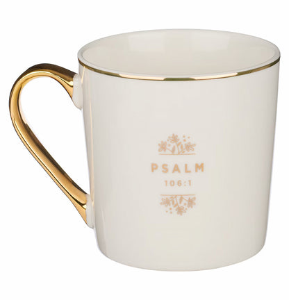 A white ceramic coffee mug with gold trim and floral design, handle facing to the side, with the text 'GIVE THANKS TO THE LORD' on the front.